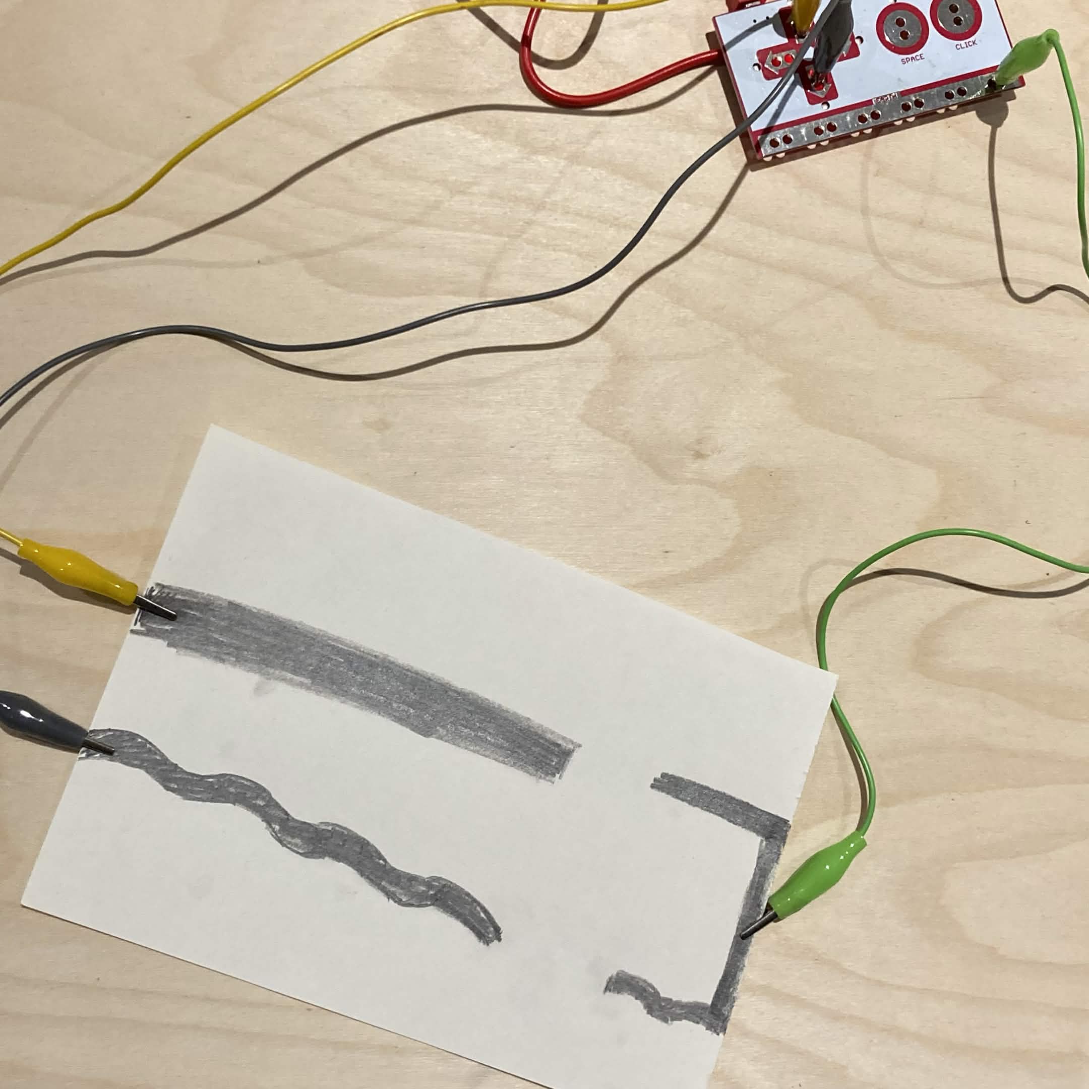 Graphite circuit that can be connected using your hand or another conductive item to trigger the Makey Makey functions.